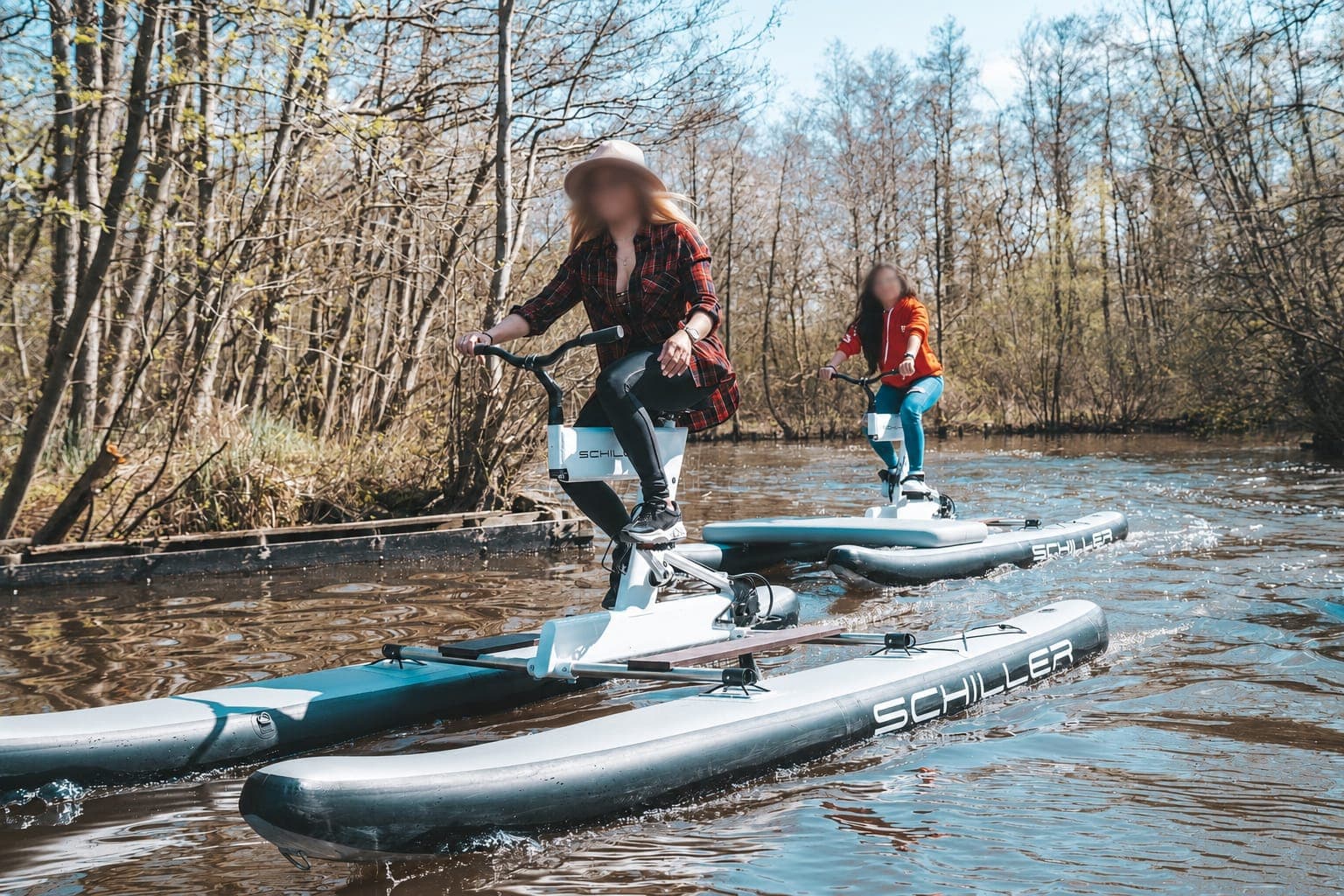 Deux personnes sur des water bikes (vélos sur flotteurs) au fil de l'eau